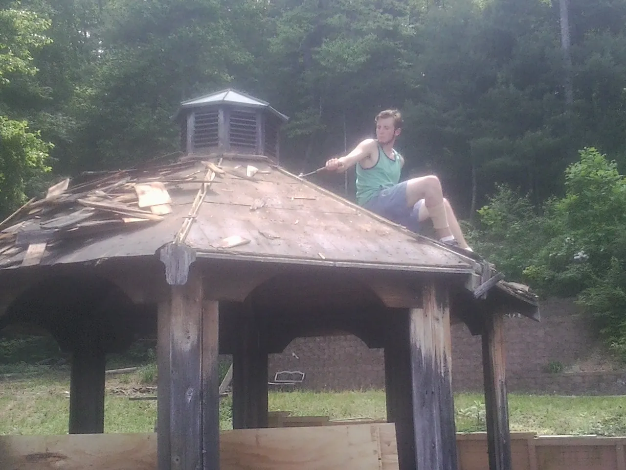 Tearing the old roof off a wooden gazebo before new shakes in Houtzdale