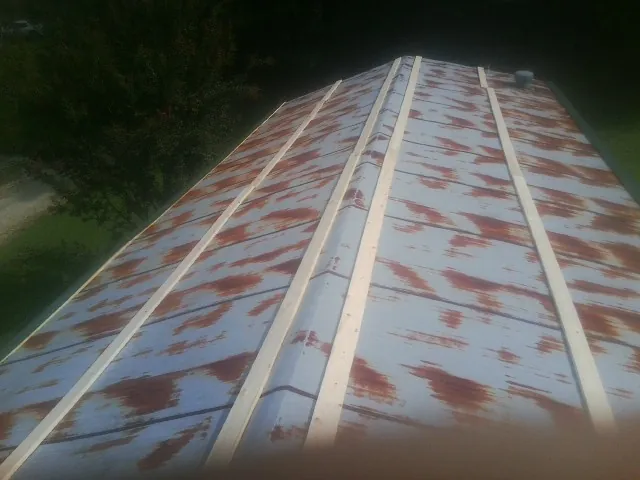 Rusted metal roof panels with new wood purlins before replacement — Storm Damage Roof Repair in Houtzdale by Roofing Brothers