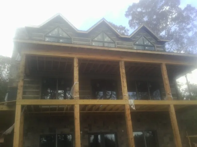 Dormers and porch framing on a large log home under construction — Roof Coating work by our crew in Houtzdale